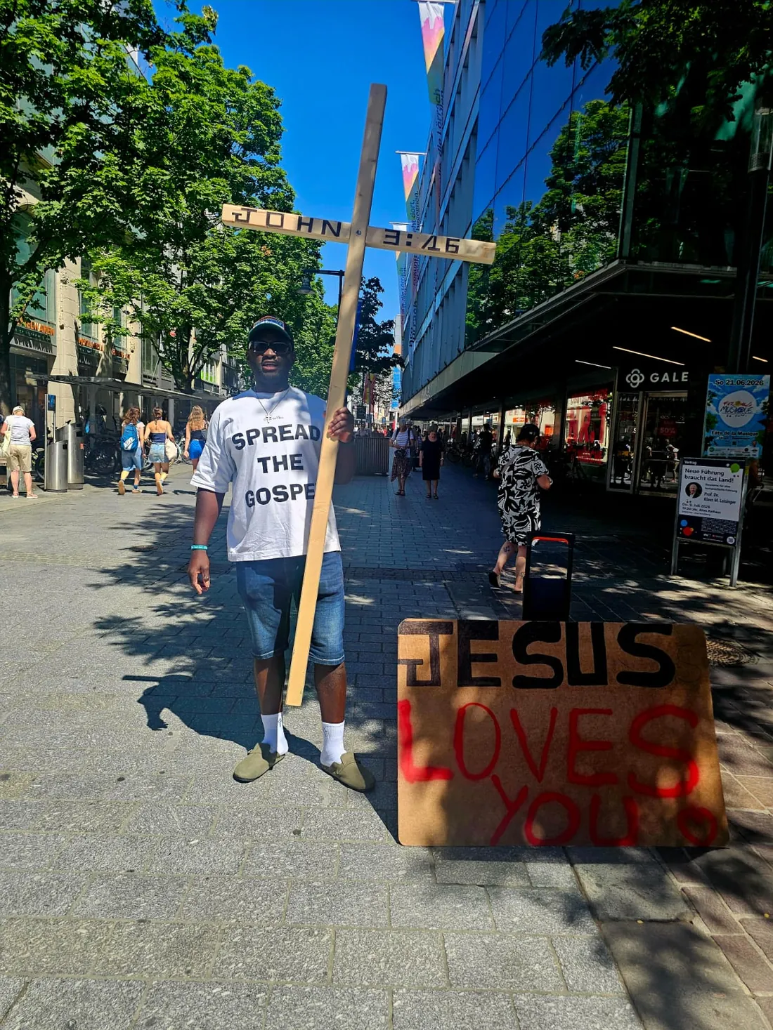 Ein Holzkreuz wird durch die Fußgängerzone getragen